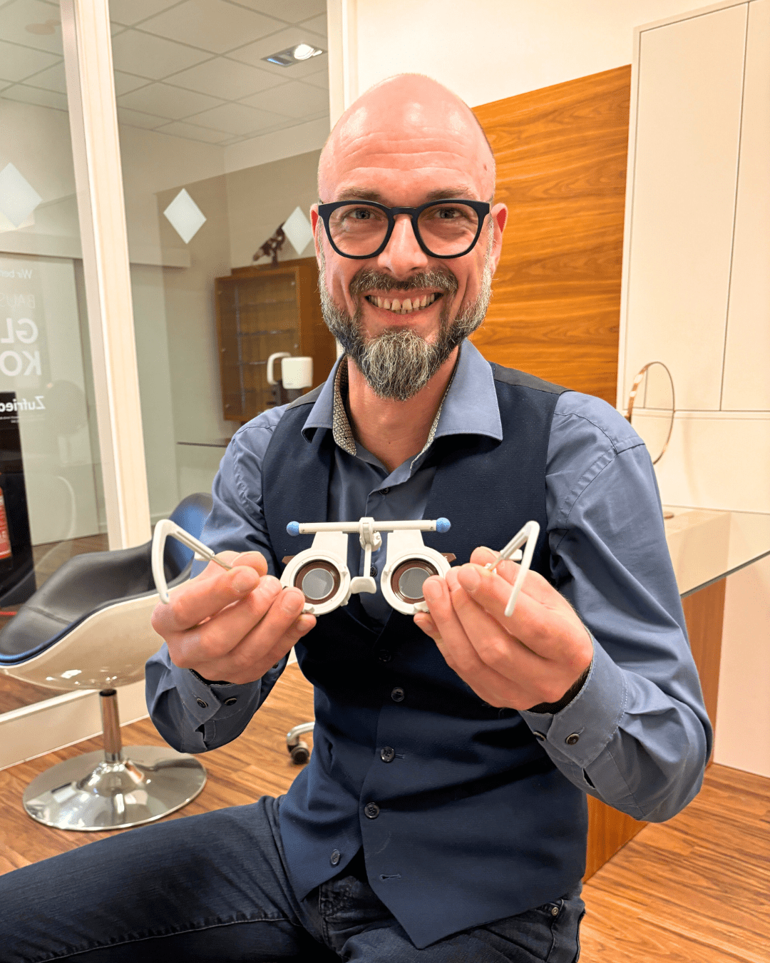 Erfahrener Augenoptikermeister führt im Brillenladen Optiko in Hamburg einen Sehtest (hier subjektive Refraktion) zur Bestimmung der aktuellen Sehstärke mit einer Messbrille durch.