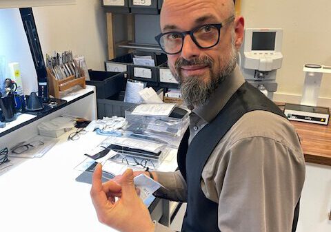 Augenoptikermeister Michael in der Werkstatt beim Anpassen einer Kunden-Brille